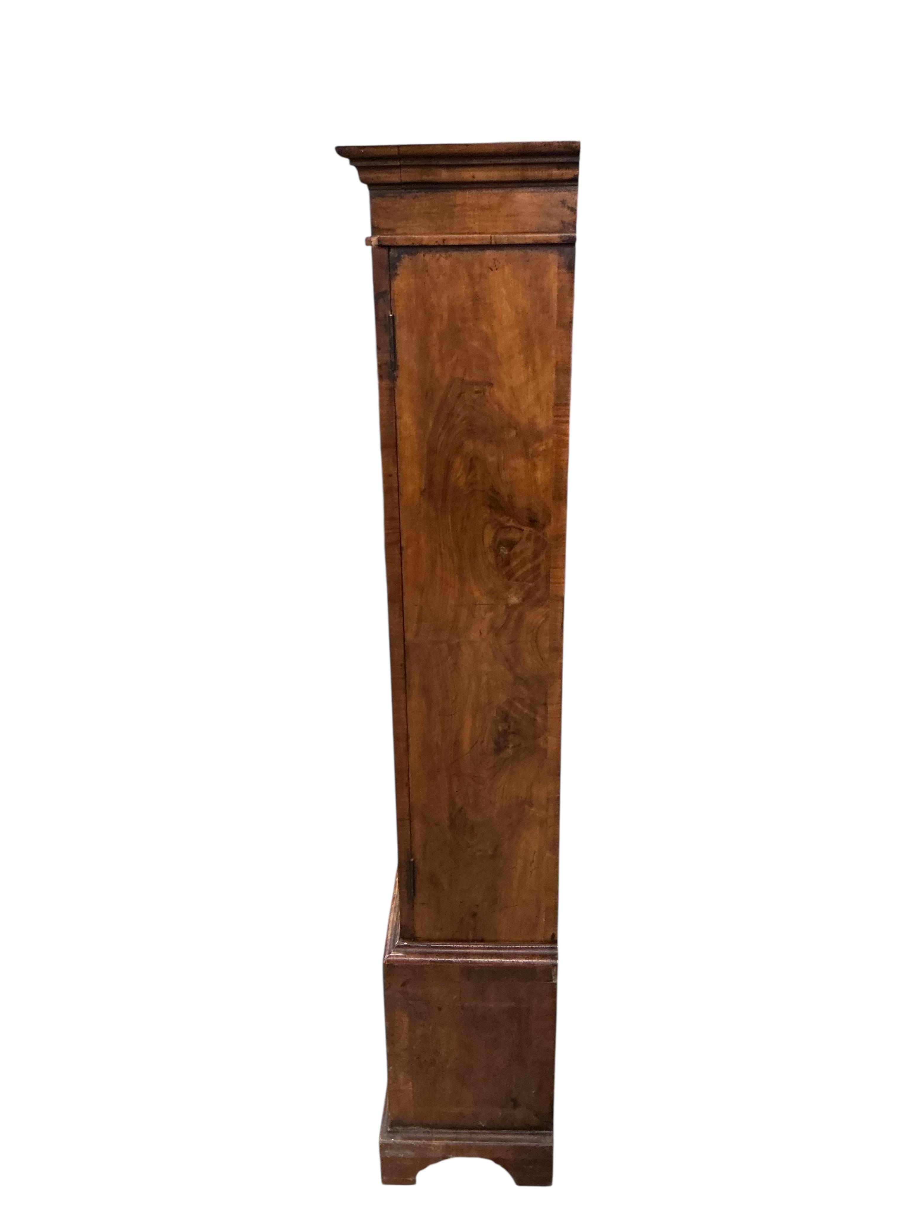 A Queen Anne Revival walnut two door bookcase, the base fitted with drawers, width 92cm, depth 27cm, height 154cm